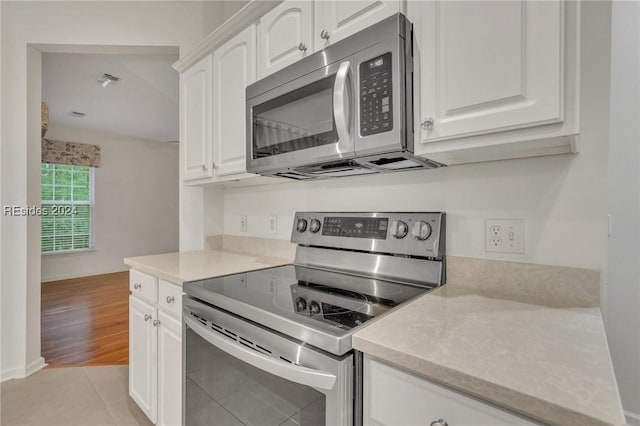 kitchen with white cabinetry, light tile patterned flooring, and appliances with stainless steel finishes