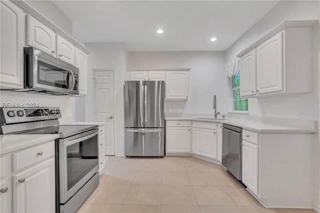 kitchen featuring stainless steel appliances, white cabinetry, sink, and light tile patterned floors