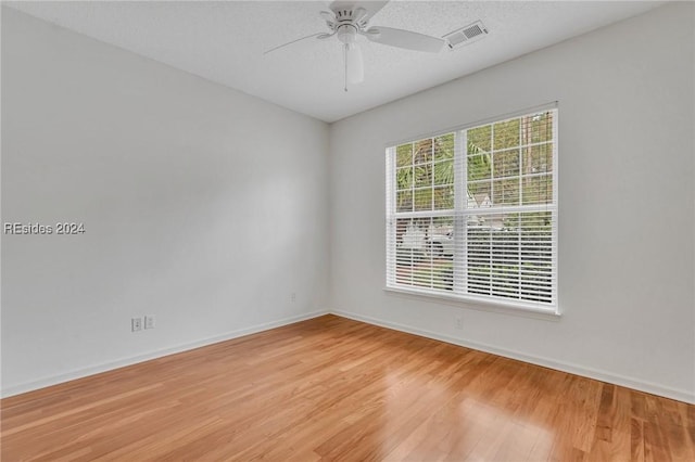 spare room with ceiling fan and light wood-type flooring