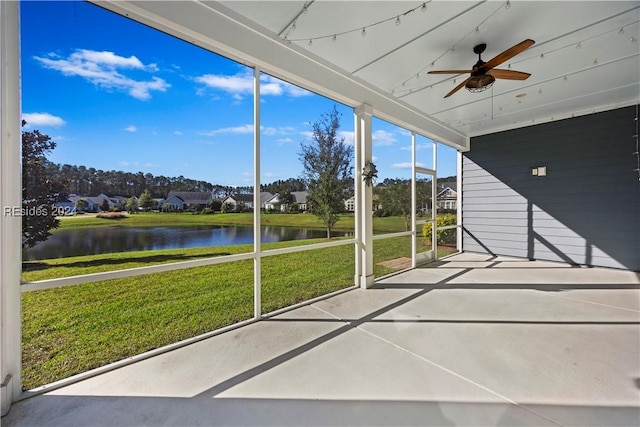 unfurnished sunroom with a water view and ceiling fan