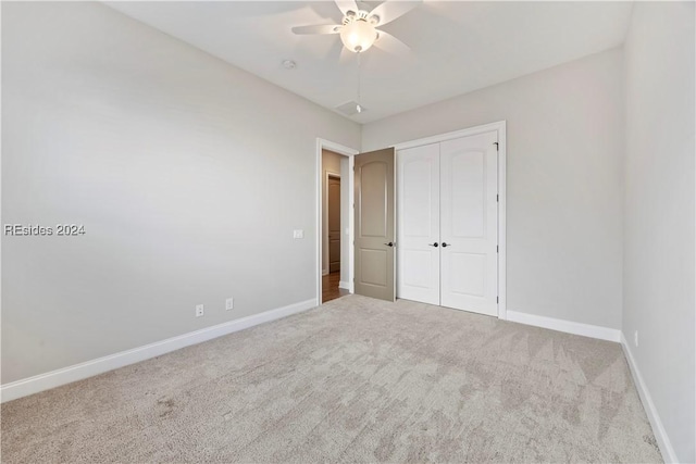 unfurnished bedroom with a closet, ceiling fan, and carpet flooring