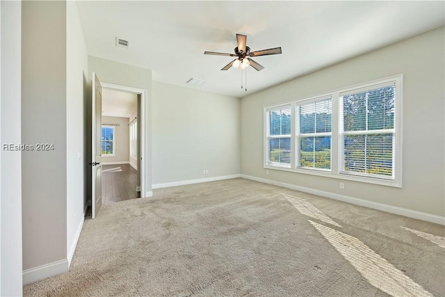 carpeted spare room featuring ceiling fan