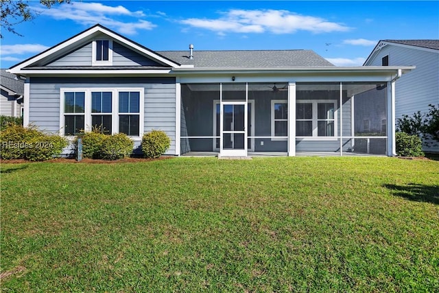 back of property with a sunroom and a lawn