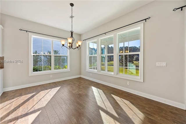 unfurnished dining area featuring dark hardwood / wood-style flooring and a notable chandelier