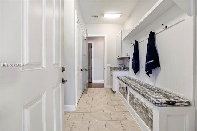 mudroom with sink and light tile patterned floors