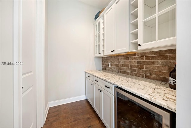 bar with dark wood-type flooring, white cabinetry, backsplash, light stone counters, and beverage cooler