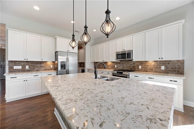 kitchen with sink, decorative light fixtures, an island with sink, and appliances with stainless steel finishes