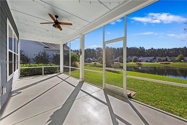 unfurnished sunroom featuring a water view and ceiling fan