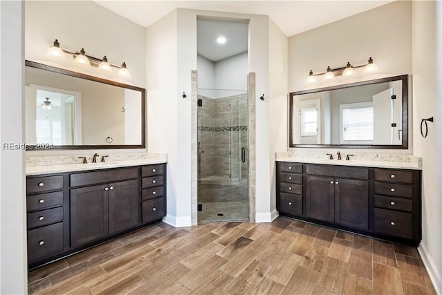 bathroom with a shower with door and vanity