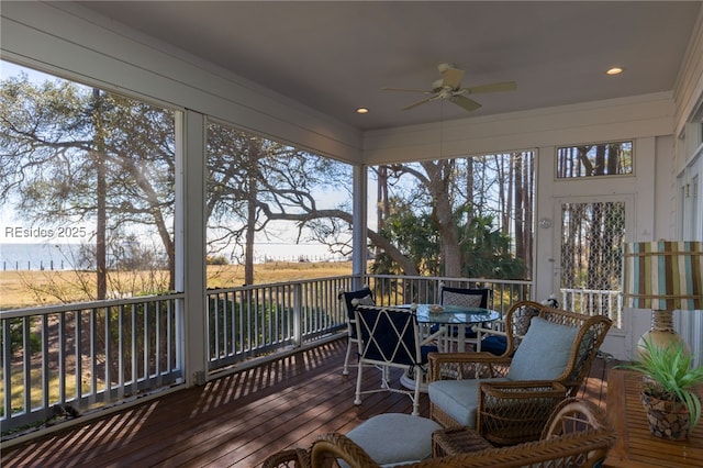 sunroom with a water view, ceiling fan, and plenty of natural light