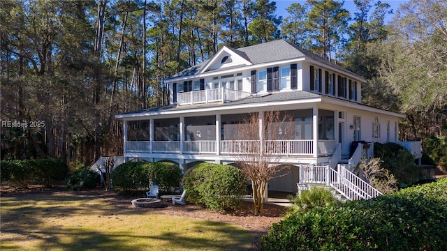 back of house with a sunroom and a lawn