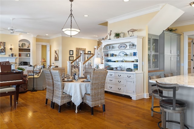 dining area with ornamental molding, dark hardwood / wood-style floors, built in features, and ceiling fan