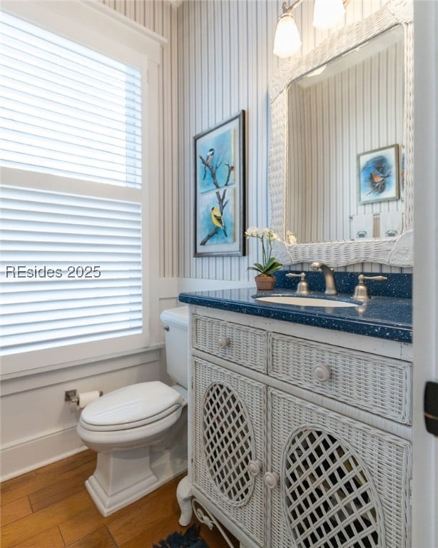 bathroom featuring vanity, wood-type flooring, toilet, and plenty of natural light