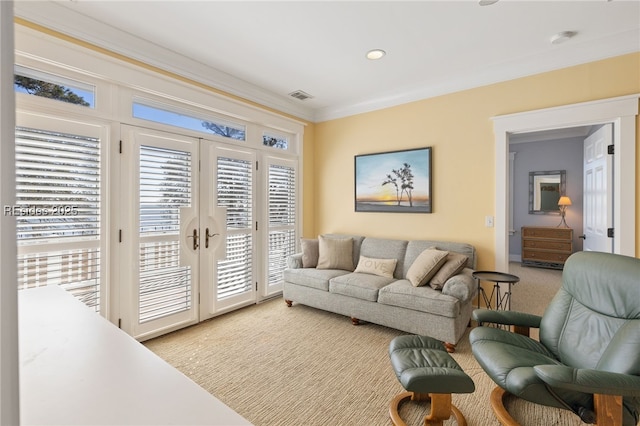 carpeted living room with ornamental molding and french doors