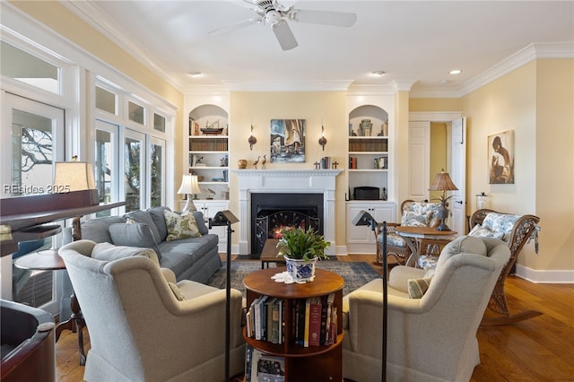 living room with ceiling fan, ornamental molding, hardwood / wood-style floors, and built in features