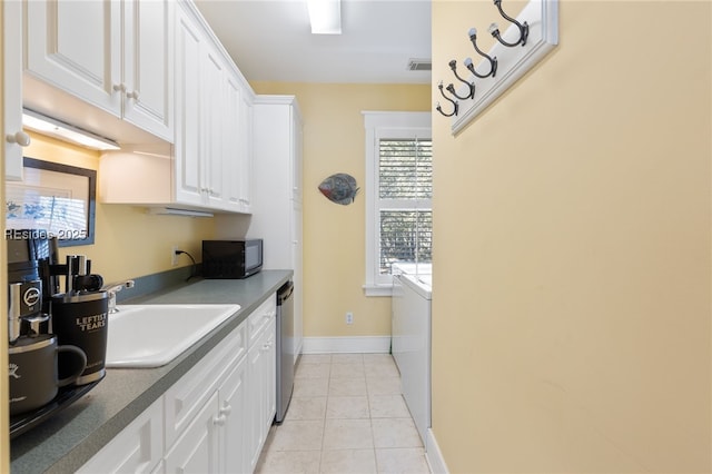 kitchen featuring white cabinetry, sink, light tile patterned floors, and dishwasher