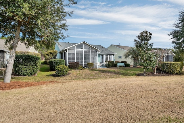 back of house with a yard and a lanai