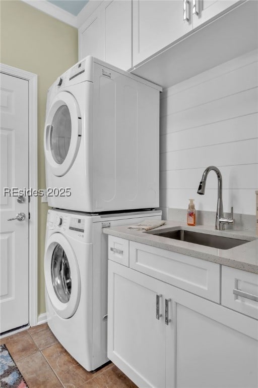 laundry room featuring cabinets, stacked washer / drying machine, sink, and light tile patterned floors