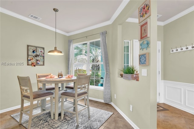 tiled dining area with ornamental molding and plenty of natural light