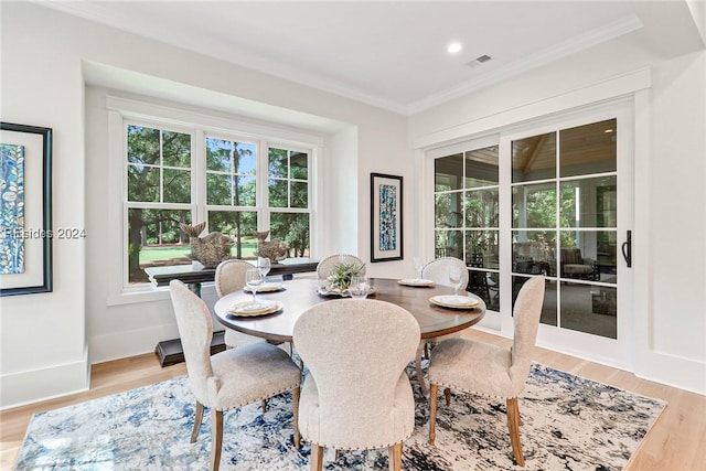 dining area with hardwood / wood-style flooring and ornamental molding