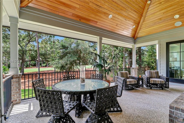 sunroom / solarium featuring wood ceiling, lofted ceiling, and a healthy amount of sunlight