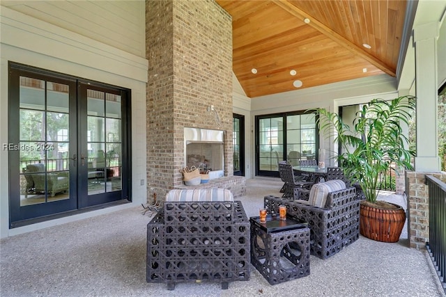 view of patio / terrace featuring an outdoor brick fireplace and french doors