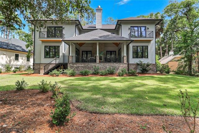 view of front of home with a balcony and a front lawn