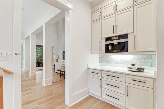 kitchen featuring white cabinets, light hardwood / wood-style floors, and decorative backsplash