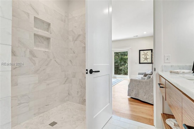 bathroom featuring vanity, tile patterned floors, and tiled shower