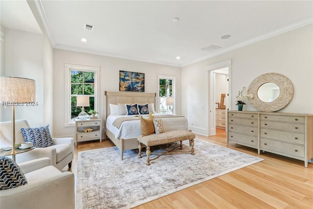 bedroom featuring connected bathroom, ornamental molding, and light hardwood / wood-style floors