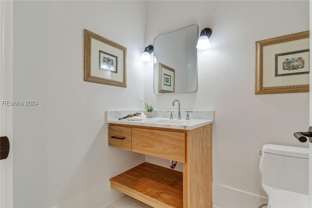 bathroom featuring vanity, tile patterned floors, and toilet