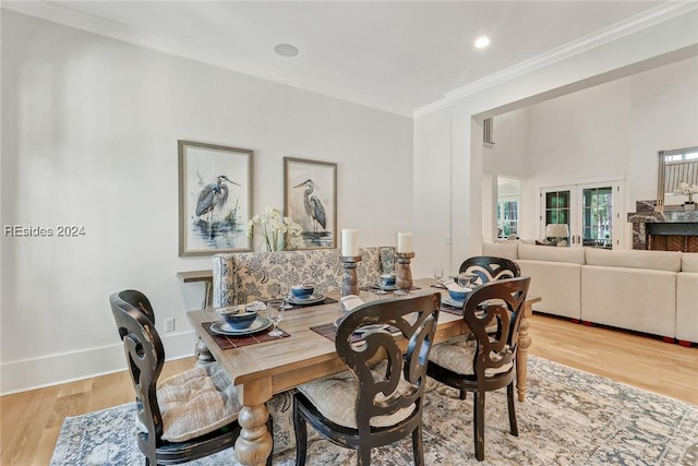 dining room with ornamental molding, french doors, and light wood-type flooring