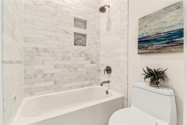 bathroom featuring toilet and tiled shower / bath