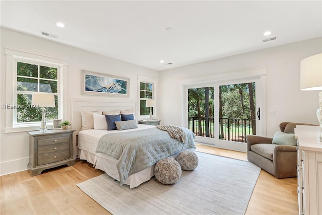 bedroom with multiple windows, access to exterior, and light hardwood / wood-style floors