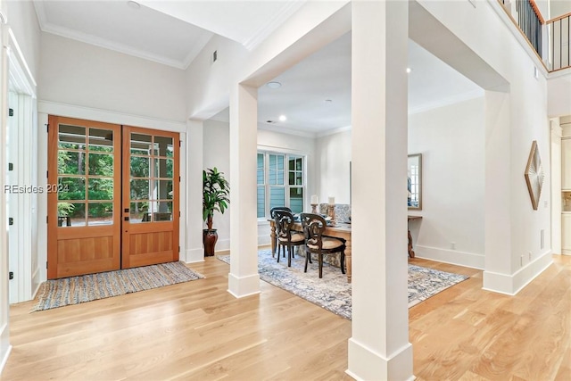 foyer with wood-type flooring, ornamental molding, french doors, and decorative columns