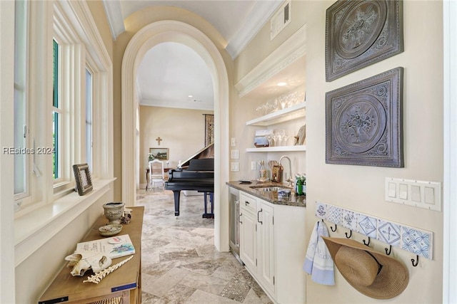 bar featuring crown molding, sink, white cabinets, and built in shelves