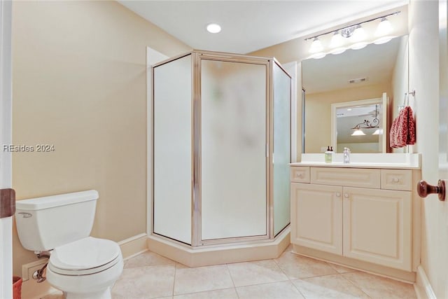 bathroom with a shower with door, vanity, tile patterned flooring, and toilet