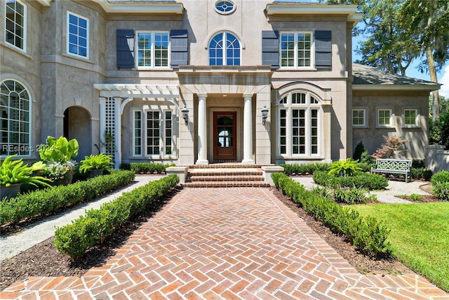 entrance to property featuring a pergola