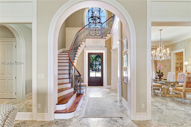 foyer entrance featuring an inviting chandelier and ornamental molding