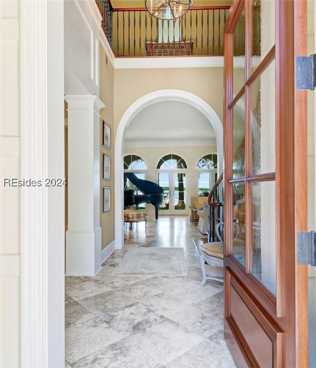 hallway with ornamental molding, french doors, and a high ceiling