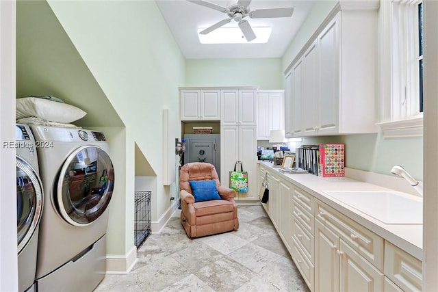 laundry area with cabinets, ceiling fan, washer and clothes dryer, and sink