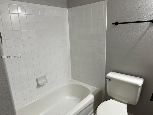 bathroom featuring washtub / shower combination and toilet