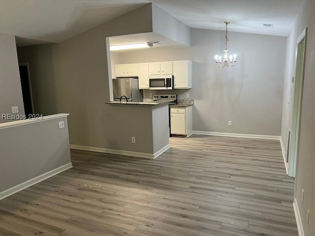 kitchen with light stone counters, a chandelier, vaulted ceiling, stainless steel appliances, and white cabinets