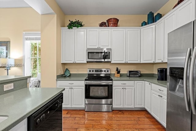 kitchen featuring appliances with stainless steel finishes, light hardwood / wood-style floors, and white cabinets