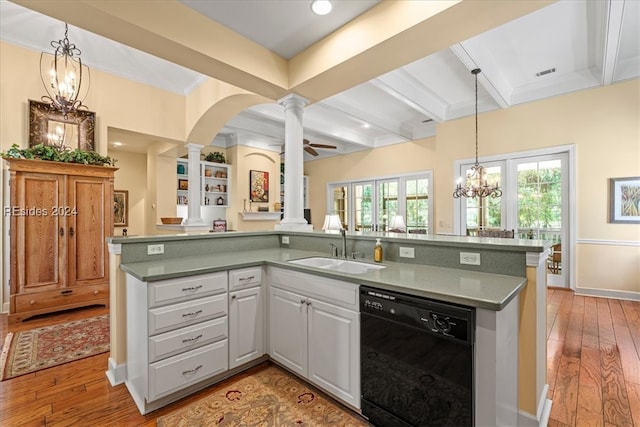 kitchen featuring decorative columns, white cabinetry, black dishwasher, sink, and light hardwood / wood-style floors