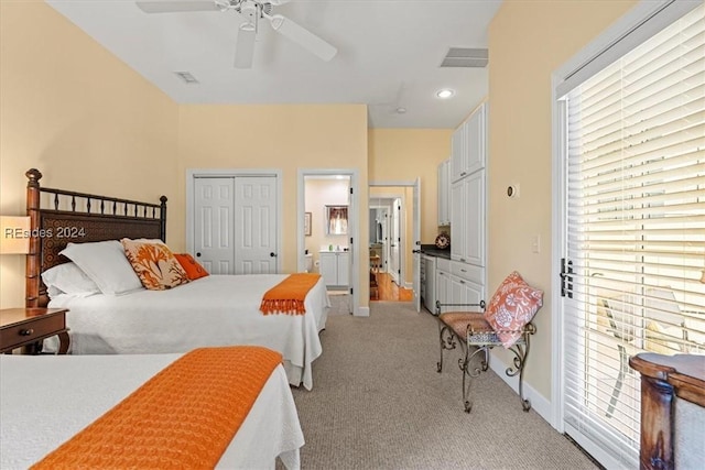 carpeted bedroom featuring a closet, ceiling fan, and ensuite bathroom