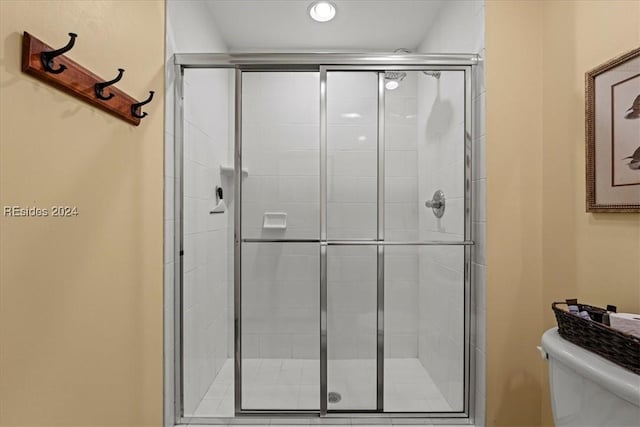 bathroom with toilet and an enclosed shower