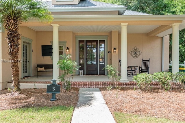 view of exterior entry featuring covered porch