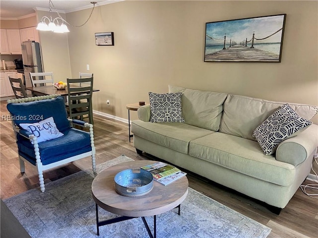 living room featuring crown molding, hardwood / wood-style flooring, and a chandelier