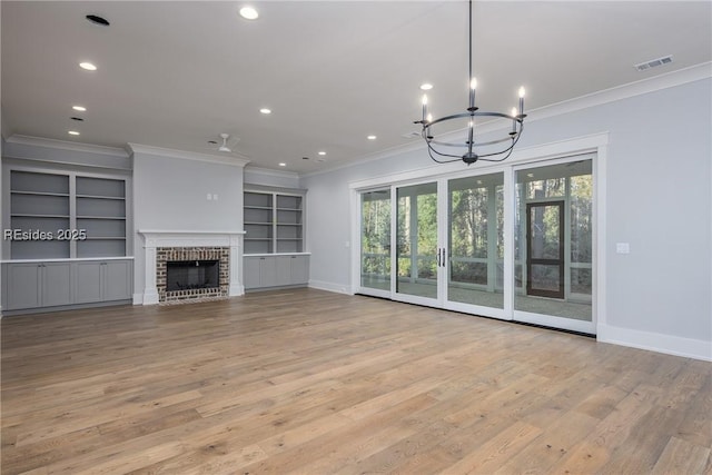 unfurnished living room featuring ornamental molding, a fireplace, and light hardwood / wood-style flooring